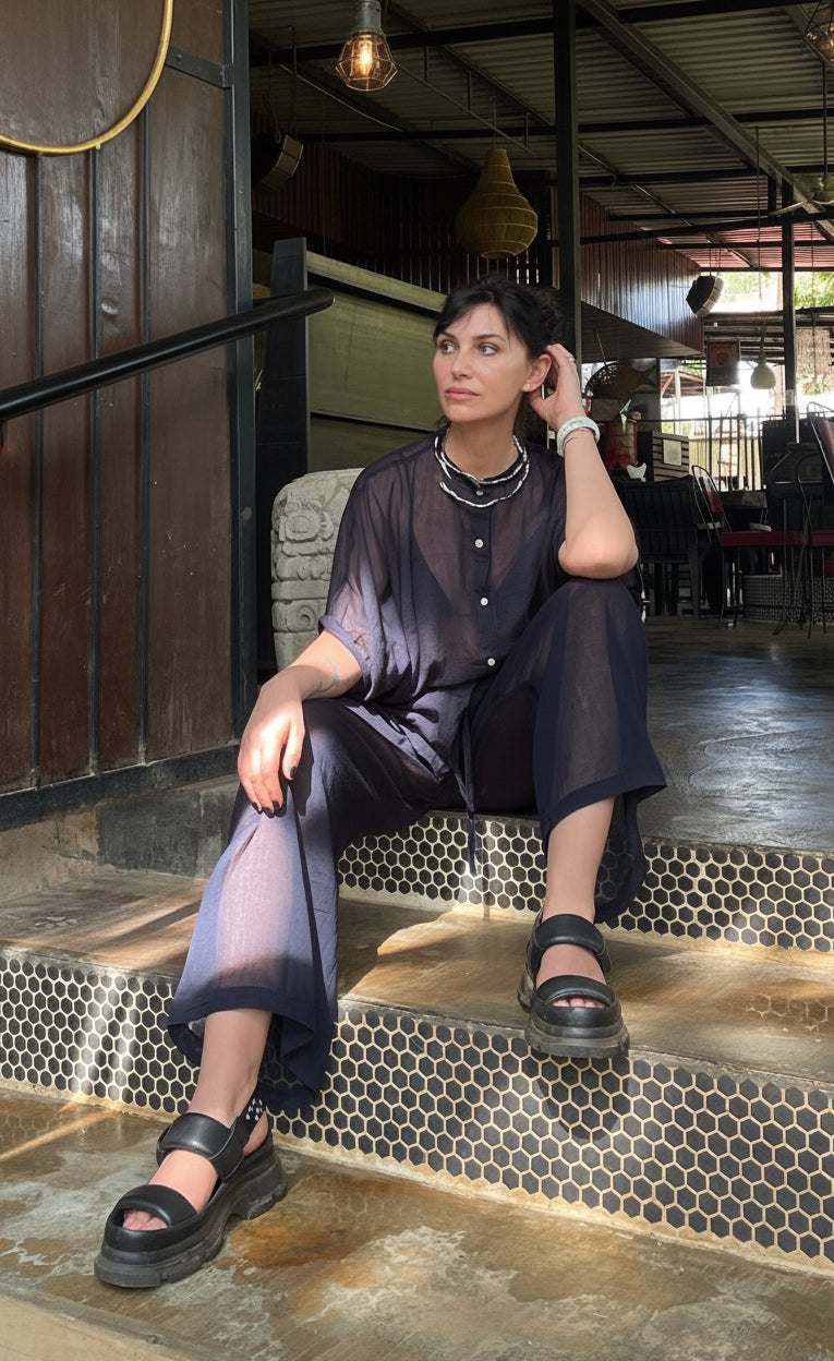 Woman sitting on steps wearing a black pajamas co-ord set 